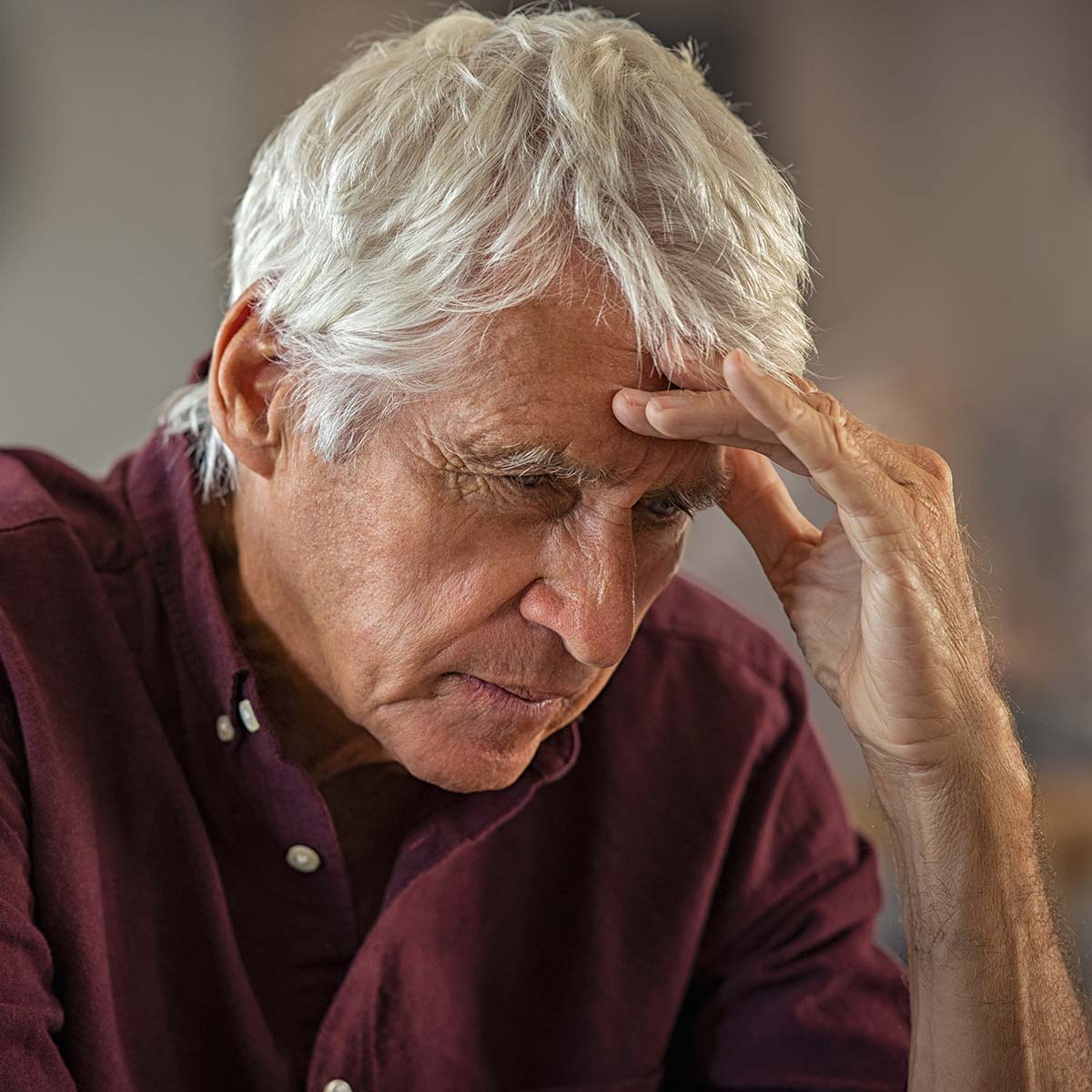 Tired and stressed old man with hand on head with headache